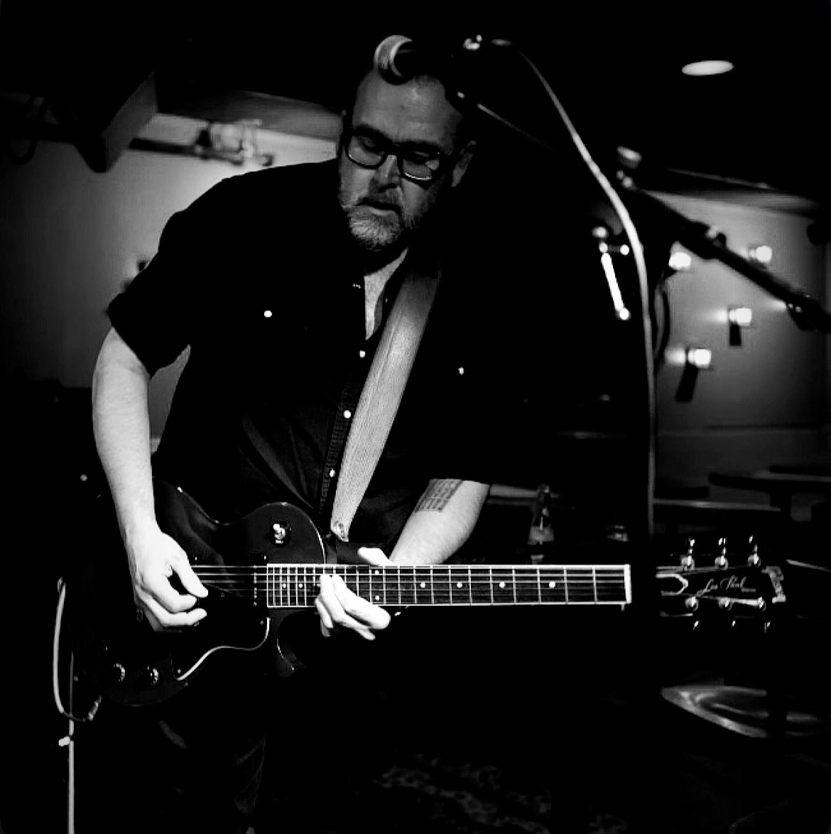 Mike Oram playing guitar live in black and white